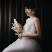 ドライフラワーのブーケを持ったウェディングドレス姿の女性の写真