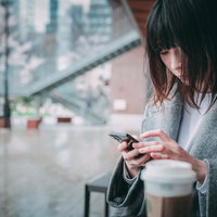 既読がつかない返信を待つカフェの窓際で悩む女子の写真