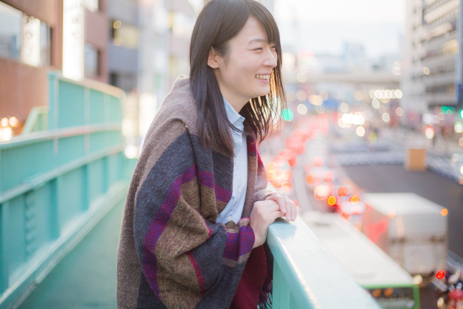 夜の歩道橋で物思いにふける若い女性［モデル：たけべともこ］