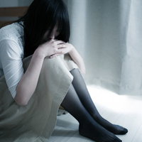 独り引きこもる失恋女子の膝抱え、悲しみに沈む心の表現の写真