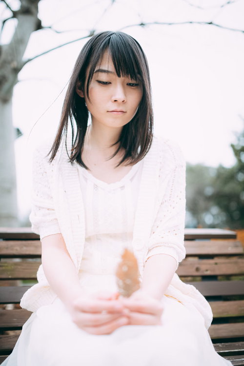 木製ベンチで自己暗示中の女性が物思いにふける