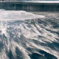 赤城山大沼の凍結した湖面に風で波状に形作られた雪の写真
