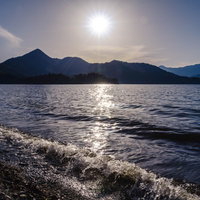 日光中禅寺湖で沈みゆく夕陽と社山のシルエットの写真