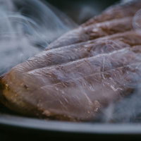 白い煙が立ち上がるエゾシカのスモーク焼きの写真