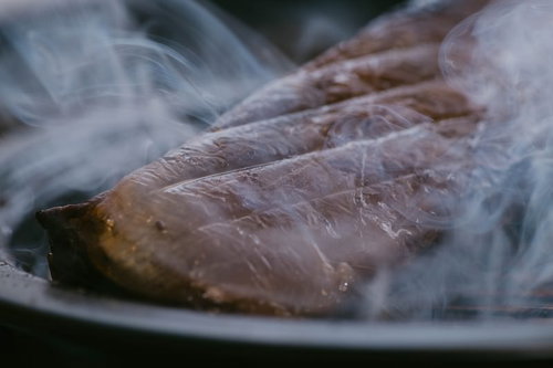 白い煙が立ち上がるエゾシカのスモーク焼き