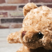 茶色い毛玉が付いたテディベアの顔のぬいぐるみの写真