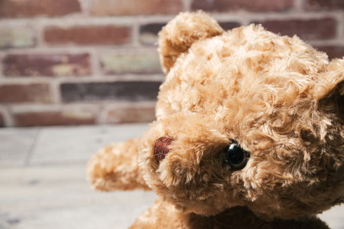 茶色い毛玉が付いたテディベアの顔のぬいぐるみ