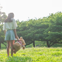 どこへ行くときもクマのぬいぐるみを連れた女の子の写真