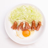 白いお皿に盛り付けたタコさんウインナーと目玉焼きの写真