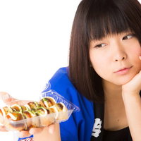粉物は高カロリー、たこ焼きを持つはっぴ姿の女性の写真