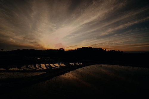港湾のクレーンや橋を背景に夕陽が沈みゆく瞬間