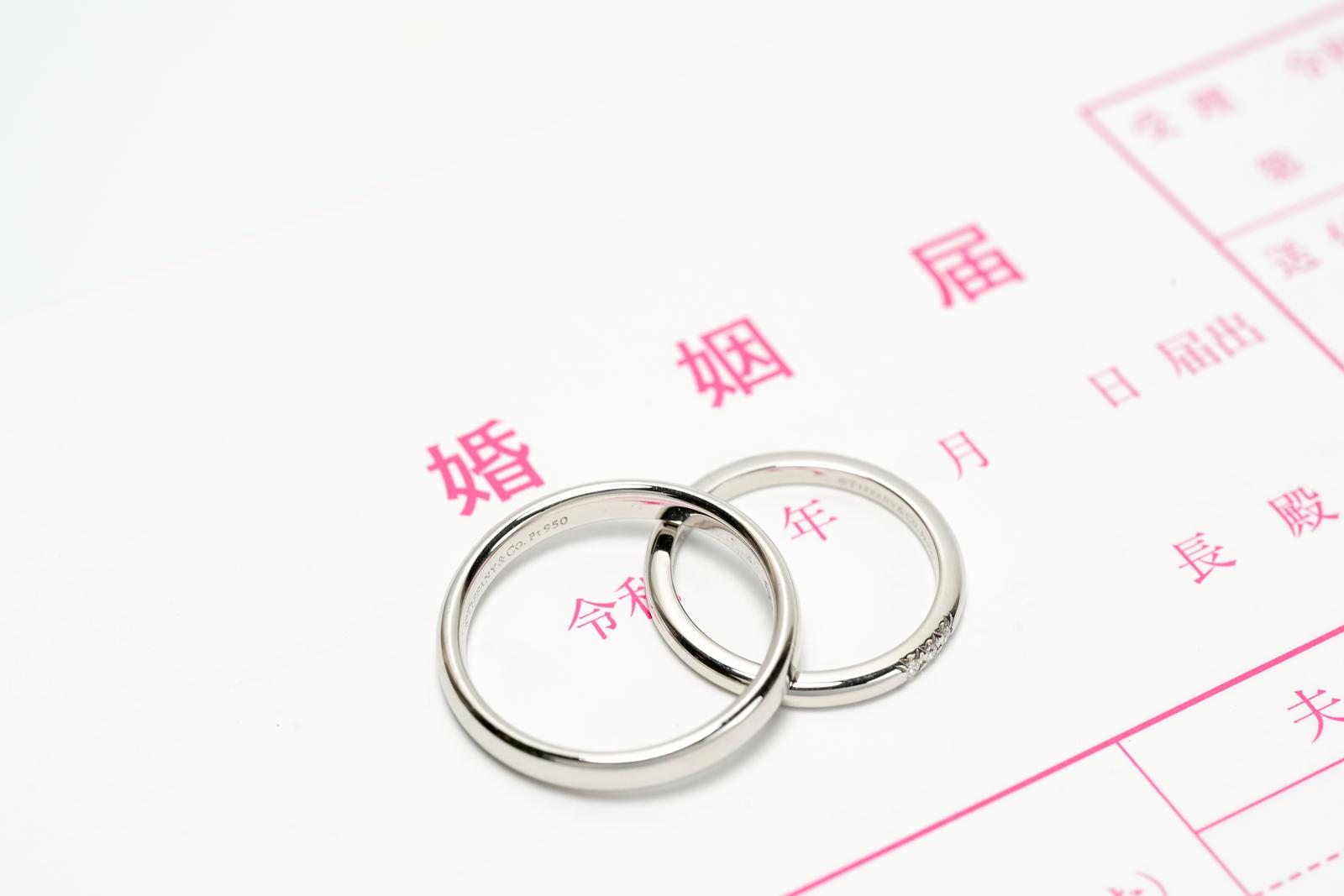 婚姻届の上に置かれた結婚指輪2本