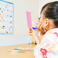 七夕の短冊になに書こうかなーと考える浴衣姿の女の子の写真