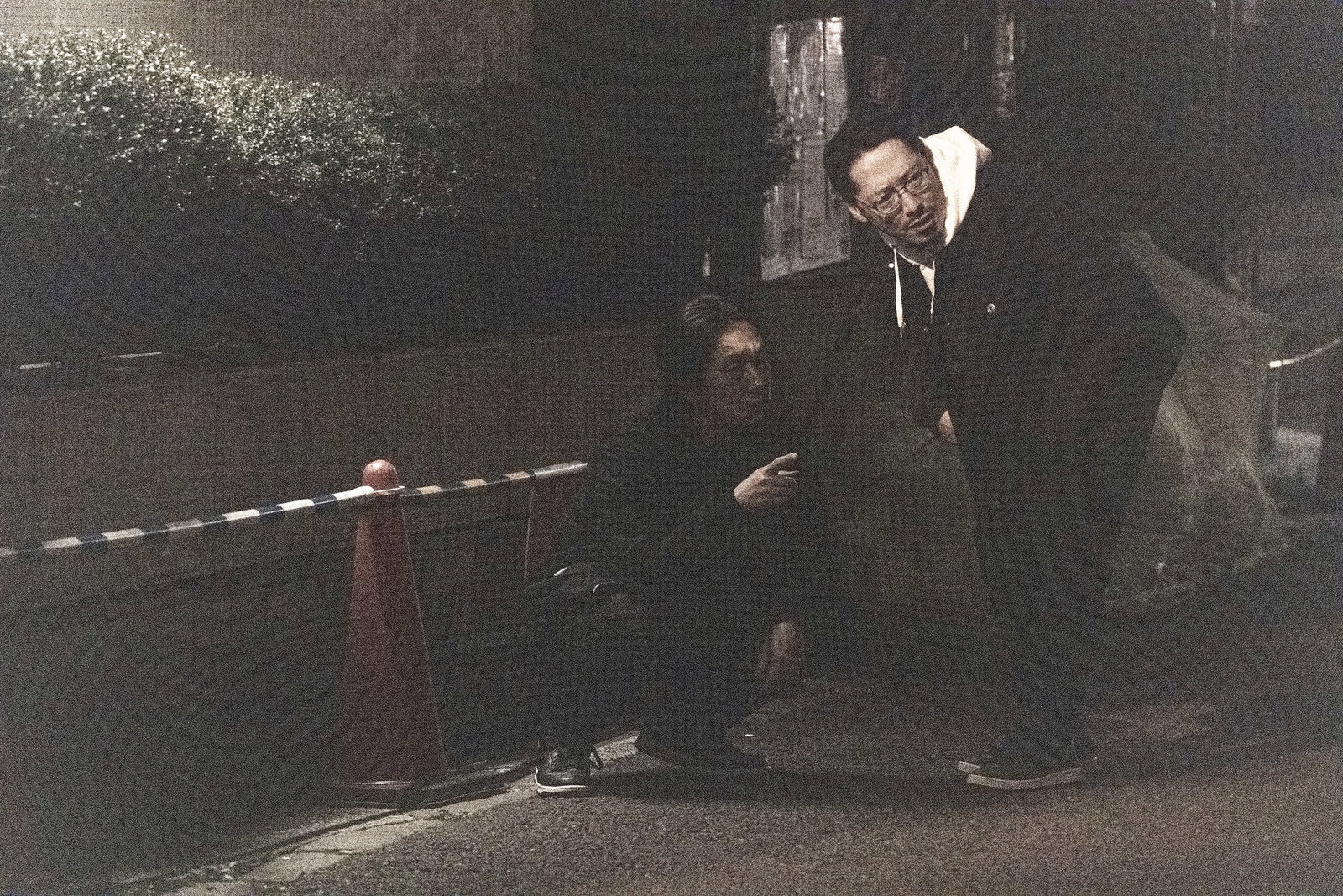 夜の暗い街で身を隠しながら尾行する男性［モデル：ゆうせい 大川竜弥］
