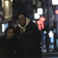 お酒を飲み過ぎて気持ち悪くなる男性と介抱する調査員の連れの写真