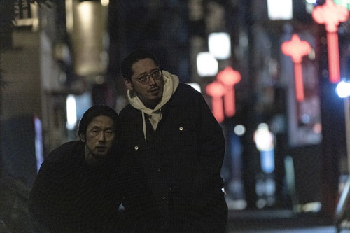 お酒を飲み過ぎて気持ち悪くなる男性と介抱する調査員の連れ