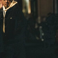 深夜の街を徘徊し尾行する男性の後ろ姿、警戒しながら歩く探偵の写真