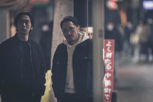 夜の中華街で調査対象を探す探偵と捜査員の張り込み現場