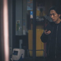 仲間と連絡を取り合い尾行する探偵の男性の捜査活動の写真