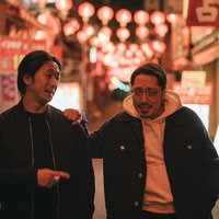 中華街の夜でほろ酔いの探偵と相棒が捜査する二人の写真