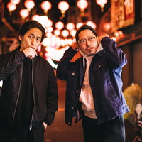 夜の中華街で張り込み中の探偵と相棒のパートナーの写真