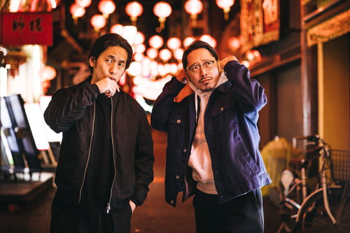 夜の中華街で張り込み中の探偵と相棒のパートナー