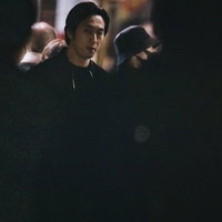 人混みの中から鋭い視線を向ける男性探偵が尾行捜査中の写真