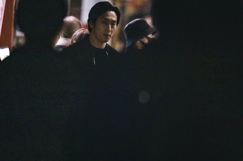 人混みの中から鋭い視線を向ける男性探偵が尾行捜査中