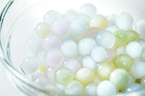 透明なガラスボウルに入った水に戻したカラータピオカ