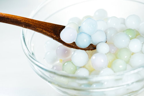 カラフルなタピオカを木製スプーンですくう