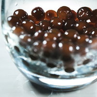 ガラス容器に詰まったブラックタピオカの粒の写真