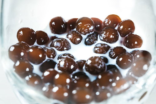 透明なグラスに入ったミルク入りブラックタピオカ