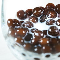 グラスの底に沈んだブラックタピオカとミルクの写真