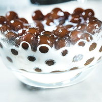 沈殿したタピオカに牛乳を注ぐ瞬間のドリンクレシピの写真