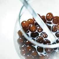 グラスの底に沈殿したブラックタピオカの写真