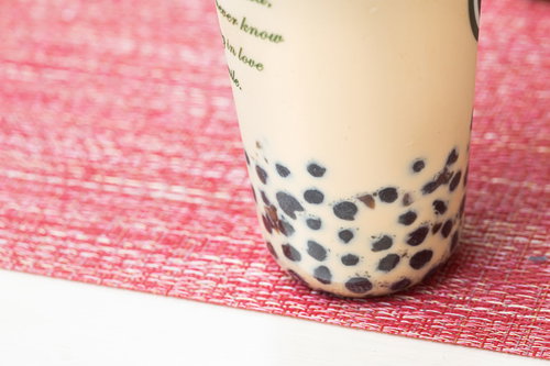 透明なカップに入ったタピオカ入りミルクティー