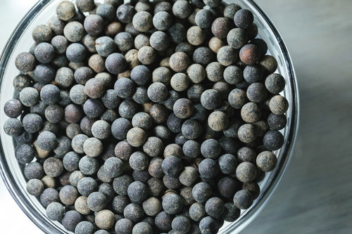 白いボウルに敷き詰められた水に浸す前のブラックタピオカ