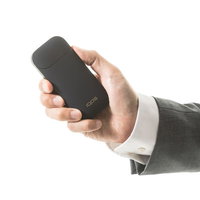 ポケットチャージャーの電源ボタンを長押しするビジネスマン（加熱式たばこ）の写真