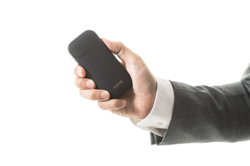 ポケットチャージャーの電源ボタンを長押しするビジネスマン（加熱式たばこ）