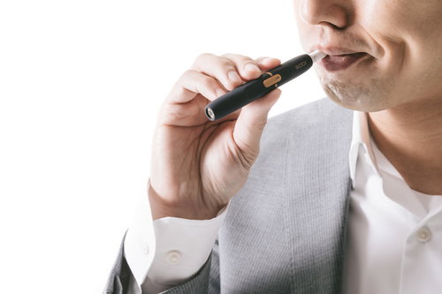 加熱式たばこの味を確かめる白いシャツの男性