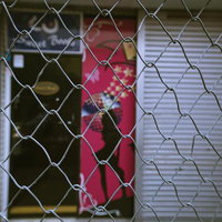 再開発で設置されたチェーンフェンスと閉鎖された店舗（立石駅北）の写真