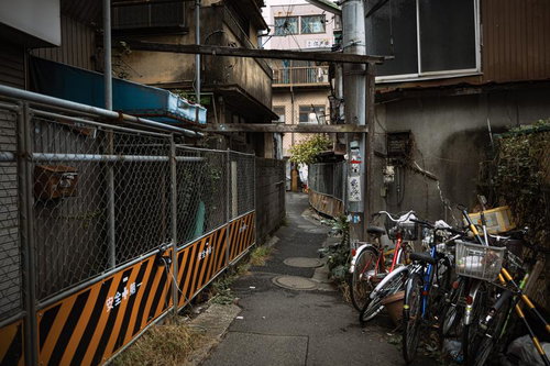 再開発の立石駅前のフェンスと路地裏に停めた自転車