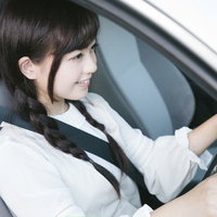 シートベルトを着用して安全運転中の女性ドライバーの写真