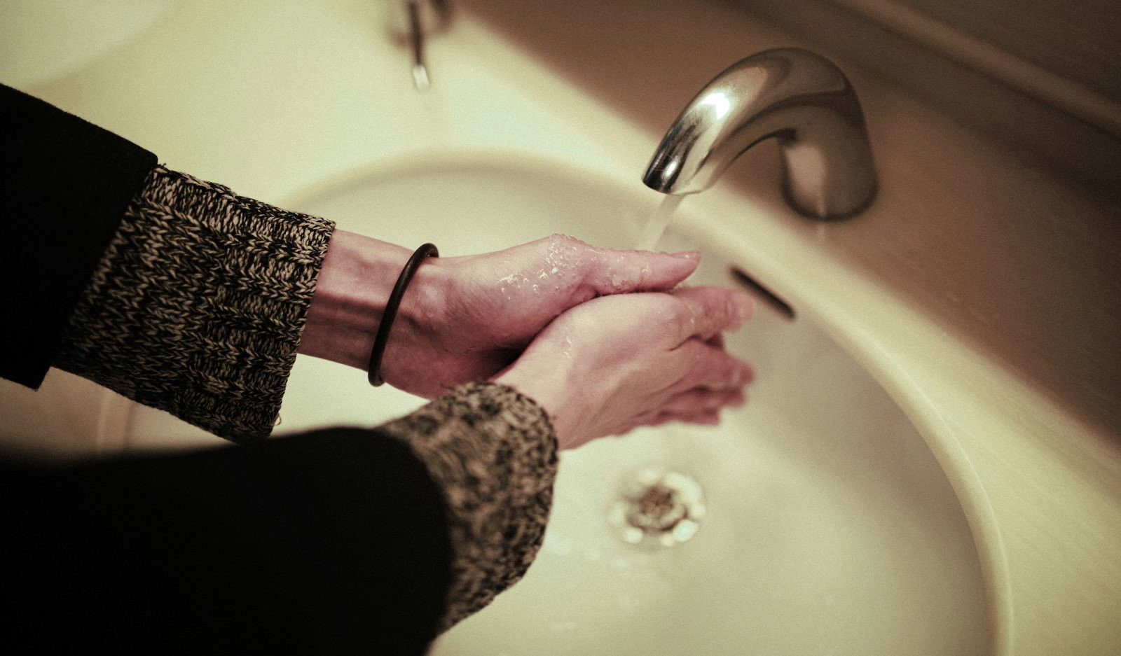 白い洗面台で石鹸を使って手洗いをする人の手［モデル：ハヤト］