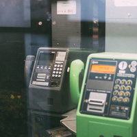 灰色と緑の電話ボックスが並ぶ夜間の風景、不気味で懐かしい昭和レトロの写真