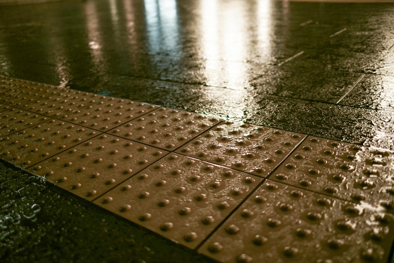 雨に濡れた点字ブロックのローアングル接写