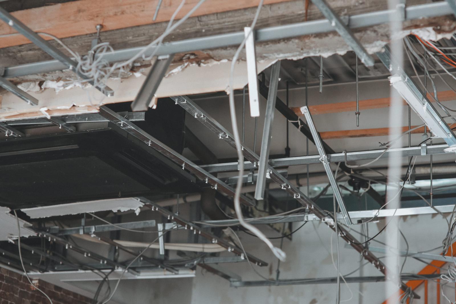 Interior with collapsed ceiling, exposed metal frame and white wiring