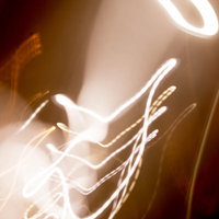 暖色系の光跡とボケが重なる抽象表現 光の流れを表現したアート背景の写真