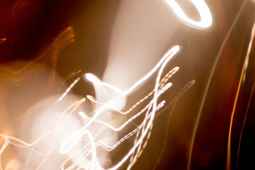 暖色系の光跡とボケが重なる抽象表現 光の流れを表現したアート背景