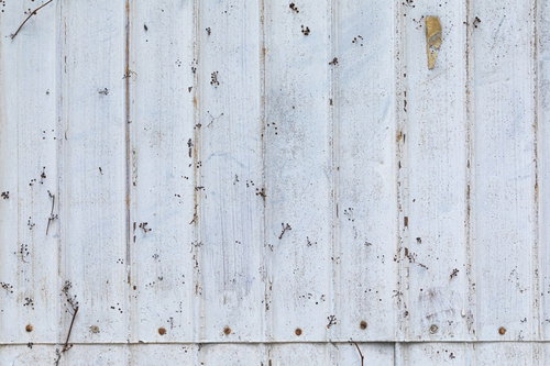 錆びてペンキを上塗りしたトタン壁のテクスチャ